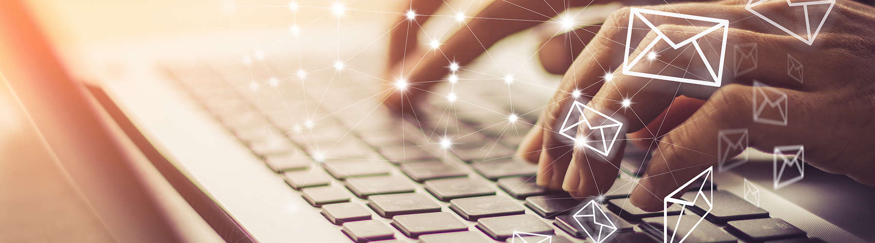 hands typing on computer keyboard with email icons floating. Symbolizing sending emails